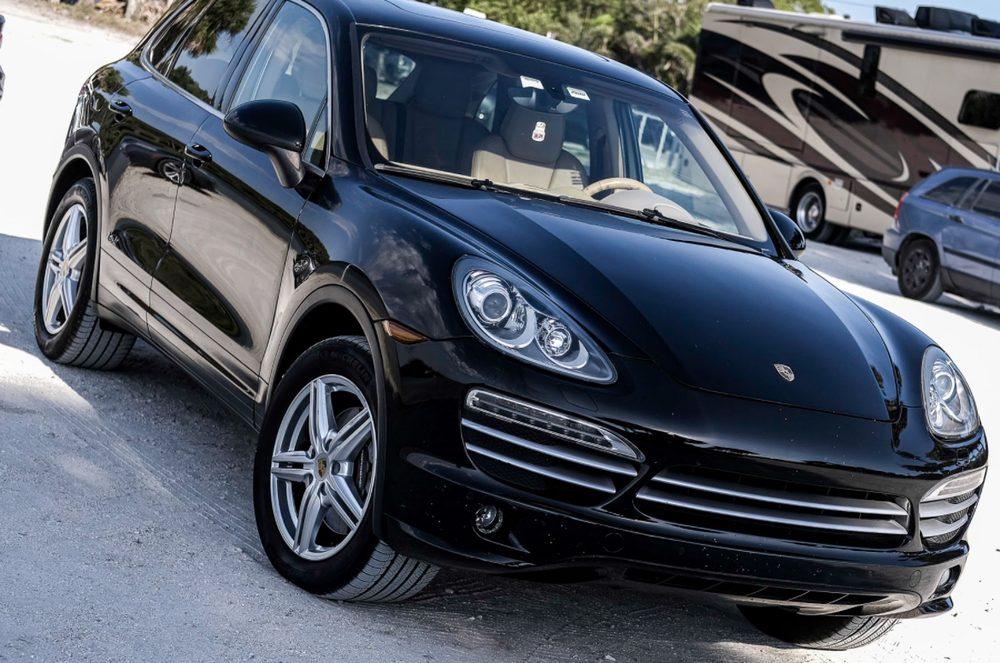 Glossy black Porsche exterior after detailing work.